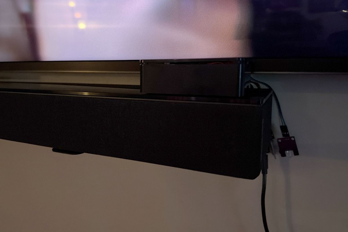 The Leveler box tucked at the right end of the soundbar under the TV